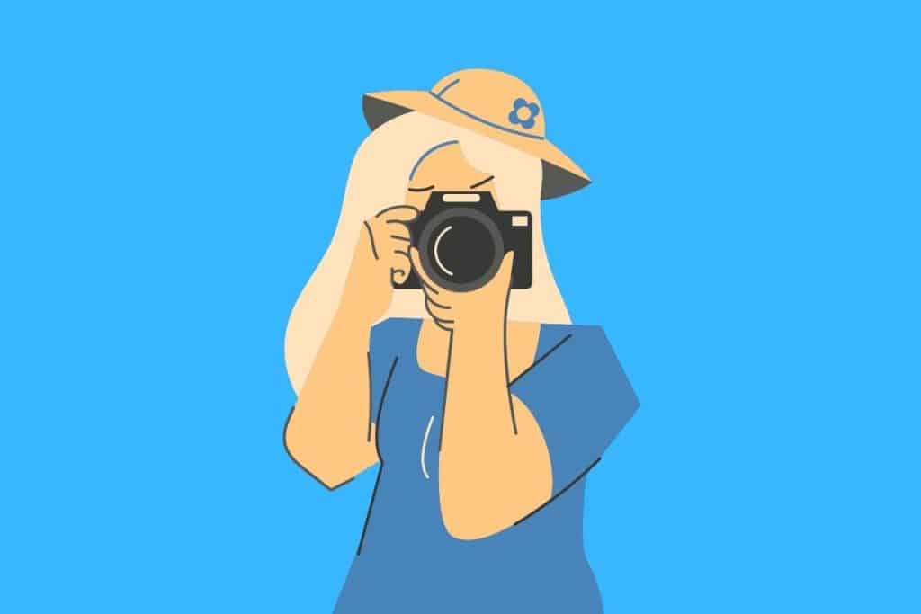 Cartoon graphic of a woman photographer taking a picture on a blue background.