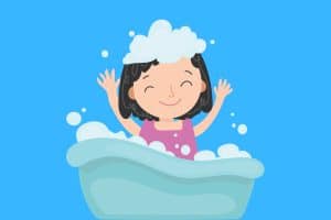 Cartoon graphic of a girl in a bath with clothes and with bubbles on her head on a blue background.